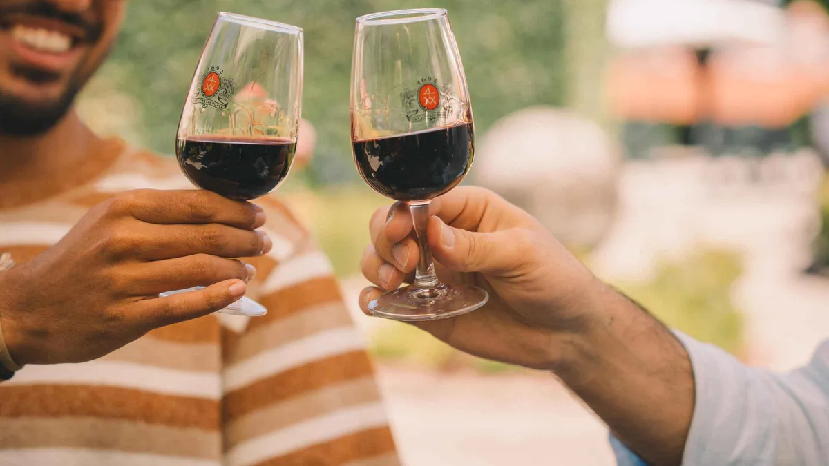 Two glasses of tawny port raised in a toast at a Porto cellar tasting