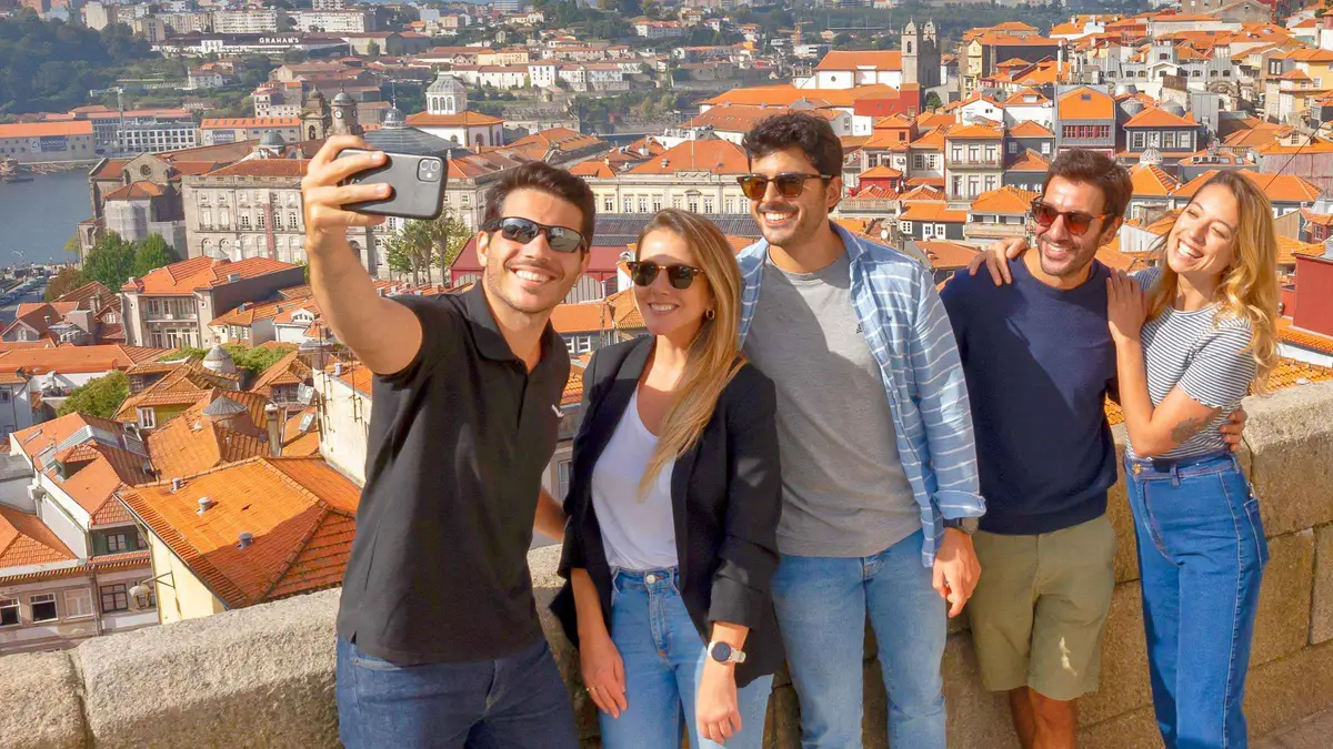 A small tour group taking a selfie above the rooftops of Porto