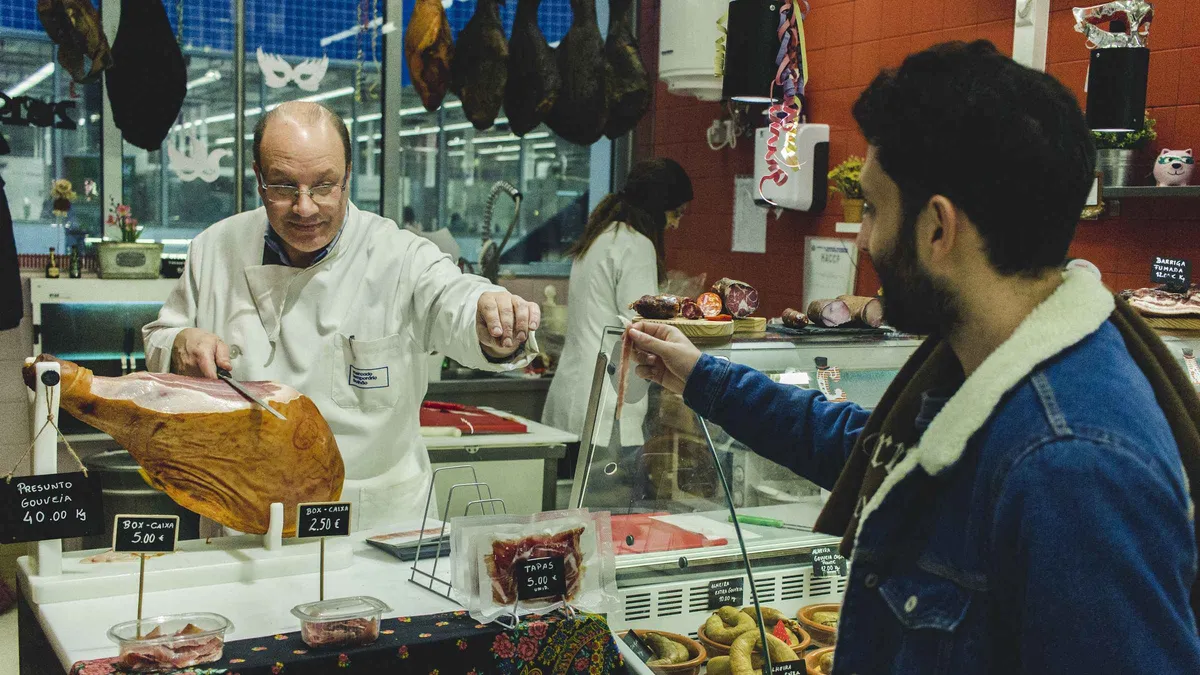 Fruit, bread and cured meats on a stall counter in the Bolhão market, the food stop on a Porto, Portugal must-see list