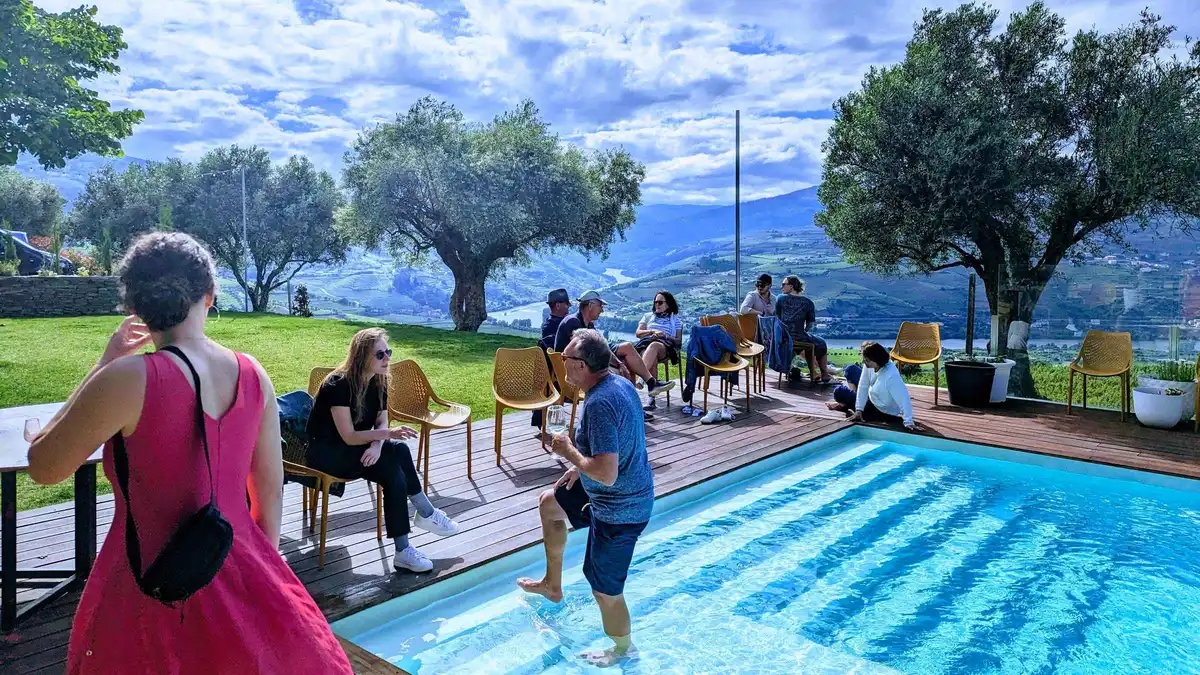 Guests relaxing by a pool at a Douro Valley wine estate on a day trip from Porto